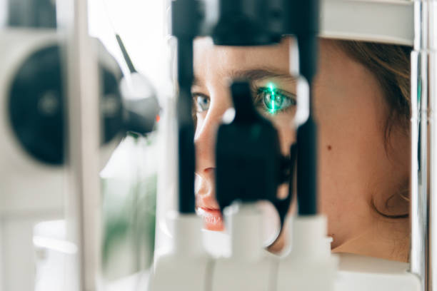 close up of woman looking through microscope